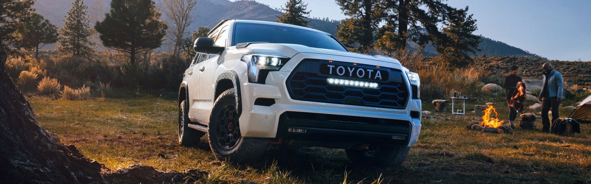 2025 Toyota Sequoia TRD Pro aparcado cerca de un camping al atardecer.